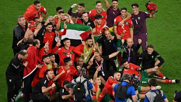 المنتخب المغربي يحتفل بالفوز على إسبانيا برفع العلم الفلسطيني (أ ف ب).