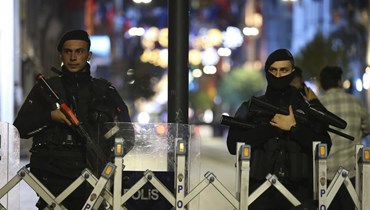 شرطيان يقفان عند مدخل شارع بعد انفجار في شارع الاستقلال في اسطنبول (13 ت2 2022، أ ب). 