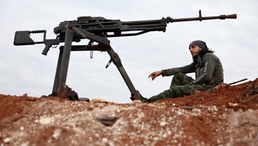مقاتل سوري مدعوم من تركيا يجلس في موقع عند أطراف بلدة مارع بالريف الشمالي لحلب (6 ك1 2022، أ ف ب). 