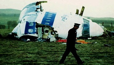 صورة ارشيفية- شرطي يمر قرب حطام طائرة في حقل قرب بلدة لوكربي باسكتلندا (21 ك1 1988، أ ب). 