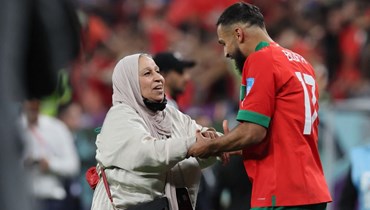 لاعب منتخب المغرب سوفيان بو فال يحتفل مع والدته على أرضية الملعب بعد الفوز على البرتغال (أ ف ب).