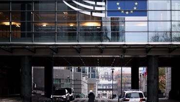 امرأة تمر قرب مدخل البرلمان الأوروبي في بروكسيل (9 ك1 2022، أ ف ب).