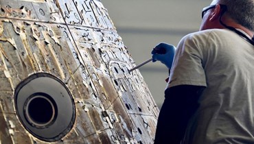مهندس في "ناسا" يتفقّد كبسولة "أوريون" بعد أن تم تأمين سقوطها بنجاح قبالة سواحل كاليفورنيا (أ ف ب). 