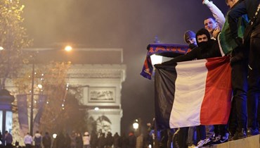 مشجعة فرنسية ترفع العلم الفرنسي في جادة الشانزليزيه (أ ف ب).