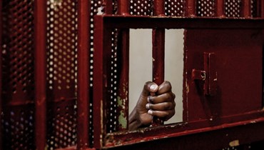   يد سجينة وهي تمسك القضبان الحديدية في زنزانتها في سجن بعبدا للنساء (أ ف ب). 