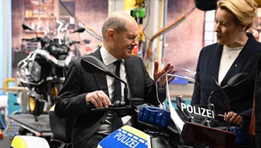 شولتس يجلس على دراجة تعمل بالكهرباء خاصة بالشرطة خلال زيارة لمصنع الدراجات النارية BMW Group Motorradwerk في برلين (19 ك1 2022، أ ف ب). 