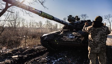 جنود أوكرانيون يحركون دبابة خلال محاولتهم إصلاح مسار، في منطقة دونيتسك شرق أوكرانيا (19 ك1 2022، أ ف ب). 