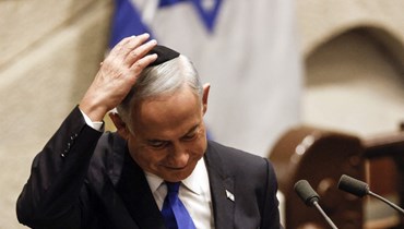نتنياهو يعدل الكيباه على رأسه بعد خطاب خلال جلسة خاصة للبرلمان الإسرائيلي في القدس للموافقة على حكومة يمينية جديدة (29 ك1 2022، أ ف ب).  