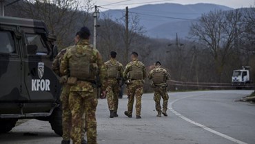 جنود من قوات "كفور" يقومون بدورية بينما يزيل صرب كوسوفو شاحنات اقامها صرب عرقيون حواجز على طريق في قرية رودار قرب بلدة زفيكان (29 ك1 2022، ا ف ب). 