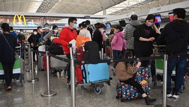 مسافرون انتظروا في المطار الدولي في هونغ كونغ (28 ك1 2022، أ ف ب). 