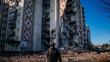 رجل يمر قرب مبنى سكني مدمر في مدينة ليمان بمنطقة دونيتسك (4 ك2 2023/ أ ف ب).
