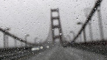 منظر لجسر "غولدن غايت" في سان فرانسيسكو بكاليفورنيا من خلف زجاج أمامي لسيارة بللته الامطار (4 ك2 2023، أ ف ب). 