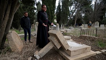 قيمون على المقبرة البروتستانتية في جبل صهيون خارج البلدة القديمة في القدس يتفقدون قبورا مخربة فيها (4 ك2 2023، أ ف ب).
