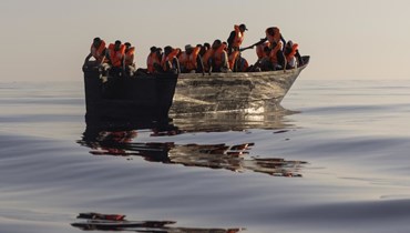 مهاجرون يبحرون في قارب خشبي بعد انقاذهم، على بعد 26 ميلًا بحريًا من جزيرة لامبيدوزا الإيطالية بالبحر الأبيض المتوسط (27 آب 2022، أ ب). 