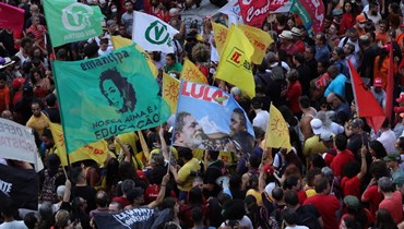 أعضاء في حركات اجتماعية يحتجون دفاعا عن الديموقراطية خلال تجمع في بورتو أليغري جنوب البرازيل (9 ك2 2023، أ ف ب). 