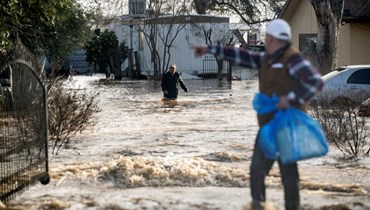 سكان يندفعون لانقاذ ممتلكاتهم قبل ارتفاع منسوب مياه الفيضانات في ميرسيد بكاليفورنيا (10 ك2 2023، أ ف ب). 