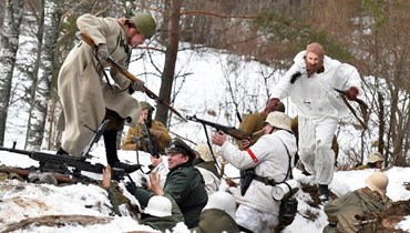 ممثلون يعيدون احياء معركة عملية "إيسكرا" خلال الحرب العالمية الثانية، في قرية دوسيفو خارج سانت بطرسبرج (15 ك2 2023، أ ف ب). 