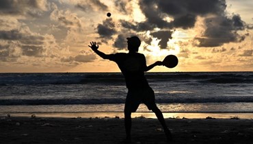 صبي يلعب أثناء غروب الشمس على شاطئ كوتا، في منتجع جزيرة بالي بإندونيسيا (أ ف ب). 