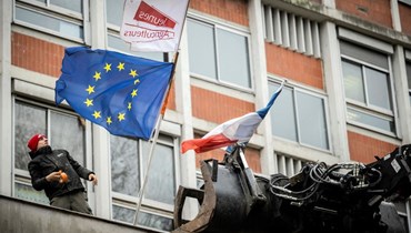 متظاهر يعلّق علم الاتحاد الأوروبي. (أ ف ب)