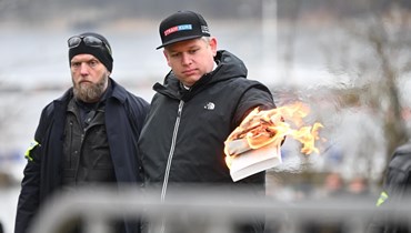 زعيم حزب "هارد لاين" اليميني المتطرف الدنماركي راسموس بالودان خلال إحراق نسخة من القرآن الكريم.
