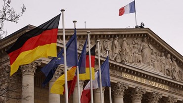 الأعلام الألمانية والاتحاد الأوروبي والفرنسية. (أ ف ب)