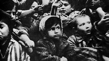 أطفال ناجون من معسكر أوشفيتز يُظهرون وشومهم (15 ك2 1945 - أ ف ب).
