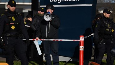 شرطيون انتشروا حول بالودان وهو يتكلم أمام مسجد في كوبنهاغن (27 ك2 2023، أ ف ب). 