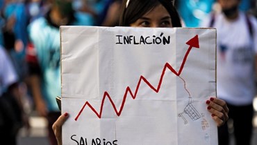 امرأة تحمل لافتة حول التضخم خلال احتجاج في بوينس آيرس (أ ف ب).