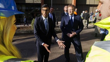 سوناك (إلى اليسار) يتحدث إلى متدربين قبل القيام بجولة في محطة الطاقة والحرارة المشتركة (CHP) في كينغز كروس في لندن (7 شباط 2023، أ ف ب). 