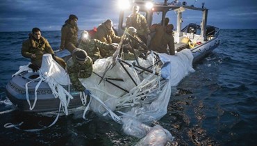 صورة وزعتها البحرية الأميركية، وتظهر بحارة يستعيدون بالون مراقبة قبالة ساحل ميرتل بيتش بساوث كارولينا (5 شباط 2023، أ ف ب). 