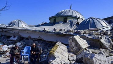 سكان يجلسون بجوار أنقاض مسجد مدمر في هاتاي (10 شباط 2023ـ أ ف ب).