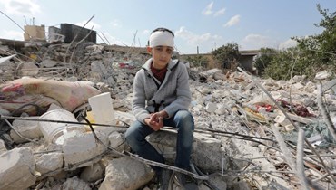فتى سوري على أنقاض منزل مدمّر في جندريس السورية المنكوبة (أ ف ب).