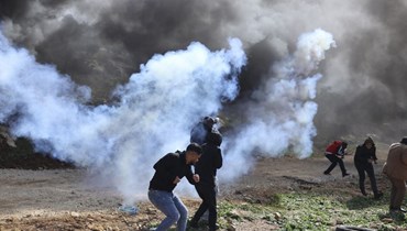 متظاهرون فلسطينيون خلال اشتباكات مع جنود إسرائيليين بعد احتجاج على إقامة بؤر استيطانية إسرائيلية، في بيت دجن شرق مدينة نابلس بالضفة الغربية المحتلة (10 شباط 2023، أ ف ب). 