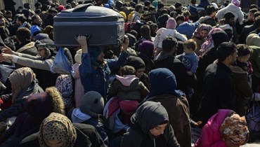 سوريون من سكان مدينة هاتاي التركية ينتظرون عبور الحدود التركية السورية عند بوابة سيلفيغوزو الحدودية (17 شباط 2023، أ ف ب). 