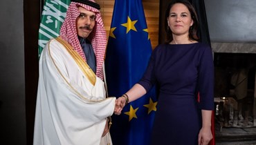 وزير الخراجية السعودي فيصل بن فرحان مصافحاً نظيرته الألمانية على هامش منتدى "ميونيخ للأمن" (أ ف ب).