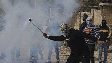 متظاهر فلسطيني خلال مواجهات مع القوات الإسرائيلية في قرية كفر قدوم في الضفة الغربية المحتلة في أعقاب احتجاج على مصادرة إسرائيل للأراضي الفلسطينية (17 شباط 2023، أ ف ب).  