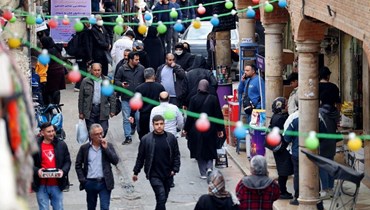 أشخاص يمشون في منطقة تجارية في طهران (21 شباط 2023، أ ف ب). 