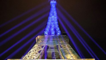 إضاءة برج إيفيل في باريس بلونَي العلم الأوكراني إحياء للذكرى الأولى للحرب (أ ف ب).