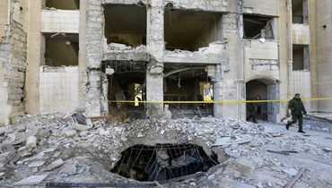 عناصر من قوات الأمن السورية يتفقدون مبنى تضرر في هجوم صاروخي إسرائيلي على دمشق (19 شباط 2023، أ ف ب). 