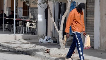 رجل يمشي في ضاحية بهار لازريغ في تونس (أ ف ب). 