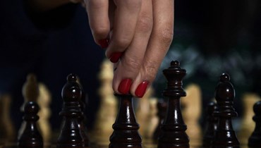 بطلة الشطرنج الإيرانية سارة خادم تقف لالتقاط صورة وهي تلعب الشطرنج في جنوب إسبانيا (أ ف ب). 