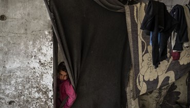 طفل سوري نازح يعيش في مبان دمرتها الحرب، في مدينة الرقة شمال سوريا (أ ف ب). 