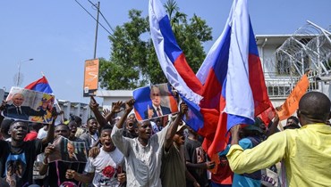 متظاهرون يلوحون بالأعلام الروسية خلال تجمع أمام السفارة الفرنسية في كينشاسا، احتجاجا على زيارة ماكرون للكونغو الديموقراطية (1 آذار 2023، أ ف ب).