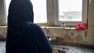 امرأة مطلّقة تم تغيير اسمها لحمايتها، تغسل الصحون خلال مقابلة مع وكالة "فرانس برس" في منزل في أفغانستان (أ ف ب). 