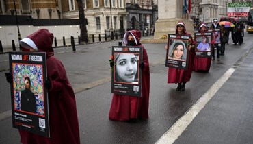 متظاهرون يحملون لافتات كُتب عليها "المرأة ، الحياة ، الحرية" أثناء تظاهرهم ضدّ اضطهاد النساء في إيران، في بوسط لندن (أ ف ب). 