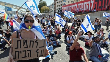 إسرائيليون يغلقون طريقا في تل أبيب احتجاجا على مشروع قانون الإصلاح القضائي (9 آذار 2023، أ ف ب). 