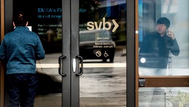 عميل (الى اليسار) يقرأ إشعارا بشأن إغلاق مصرف سيليكون فالي في المقر الرئيسي للبنك في سانتا كلارا بكاليفورنيا (10 آذار 2023، أ ف ب).