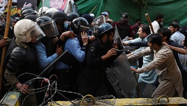 مواجهات بين أنصار خان (الى اليمين) والشرطة خارج منزل خان  في لاهور (14 آذار 2023ـ أ ف ب). 