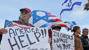 إسرائيليون يطالبون بتدخل الولايات المتحدة خلال مسيرة ضد مشروع قانون للحكومة الإسرائيلية (أ ف ب).