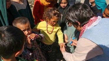 أطفال يخضعون للفحص الطبّي في أفغانستان (أ ف ب).